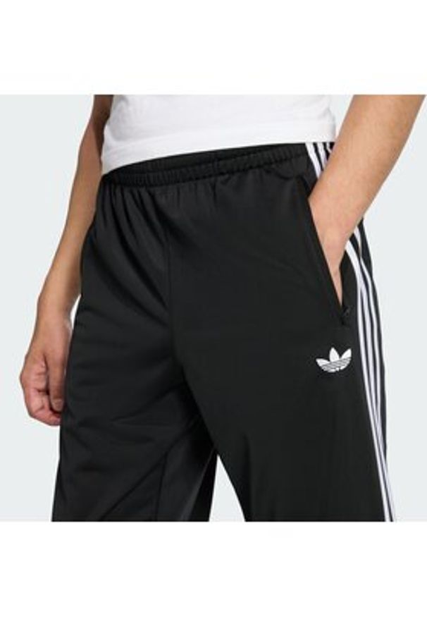 Adidas - adidas Spodnie dresowe Firebird KD8315 Czarny Loose Fit. Kolor: czarny. Materiał: syntetyk