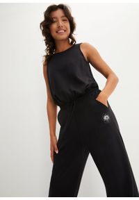 bonprix - Miękki kombinezon sportowy z szerokimi nogawkami, z szybko schnącego materiału scuba. Kolor: czarny. Materiał: materiał. Styl: sportowy