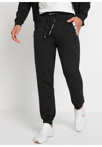 bonprix - Spodnie sportowe z modnymi szczegółami. Kolor: czarny. Styl: sportowy #1