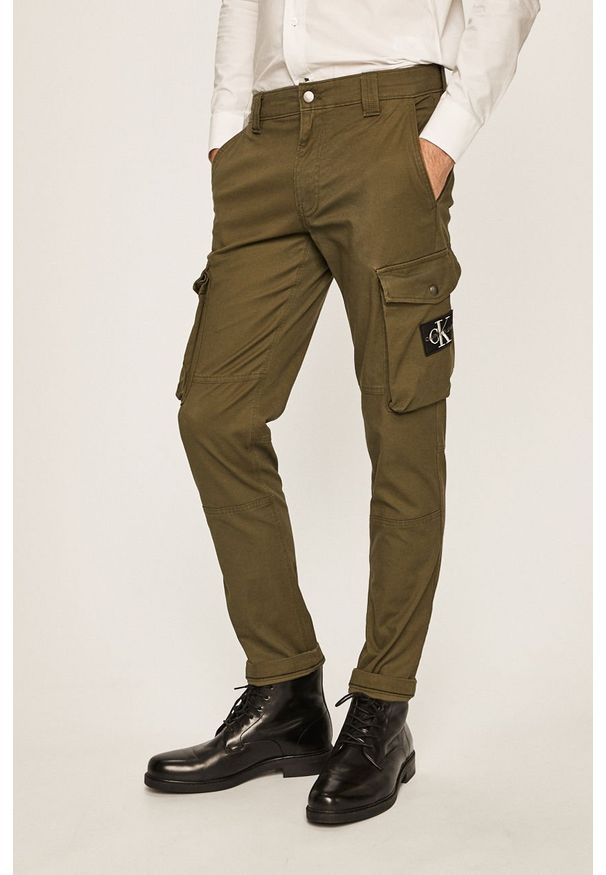 Calvin Klein Jeans - Spodnie. Kolor: zielony. Materiał: tkanina, bawełna, elastan. Wzór: gładki