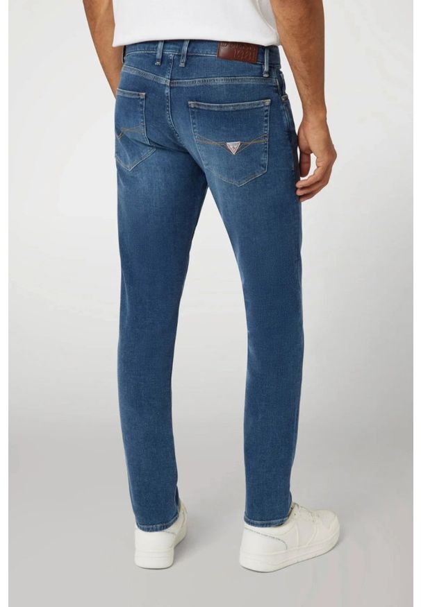 Guess - GUESS Niebieskie męskie spodnie jeansowe Finnley. Kolor: niebieski. Wzór: aplikacja. Styl: klasyczny