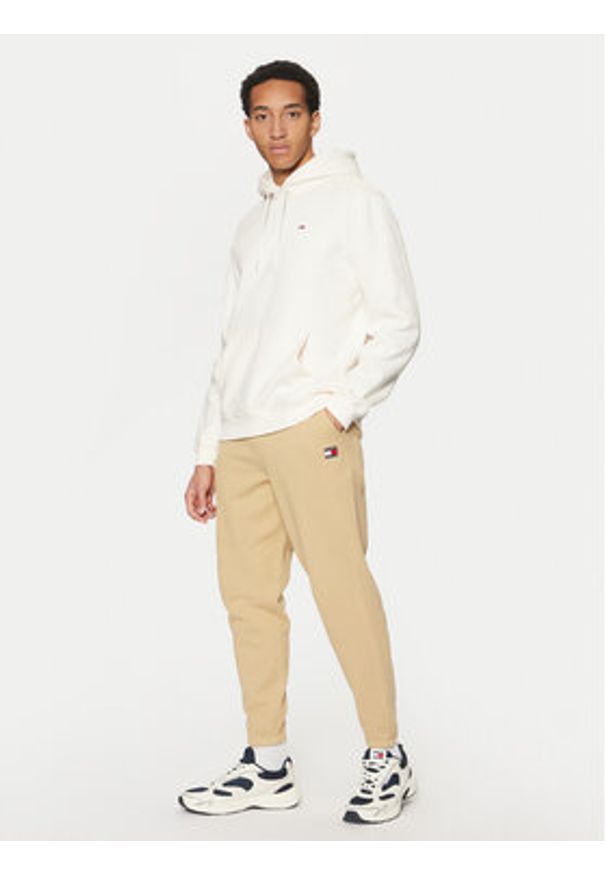 Tommy Jeans Spodnie dresowe Badge DM0DM20276 Beżowy Regular Fit. Kolor: beżowy. Materiał: bawełna