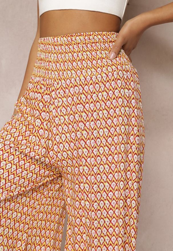 Renee - Żółto-Pomarańczowe Szerokie Spodnie z Wiskozy z Marszczoną Gumką w Talii Mellody. Kolor: żółty. Materiał: wiskoza. Styl: boho