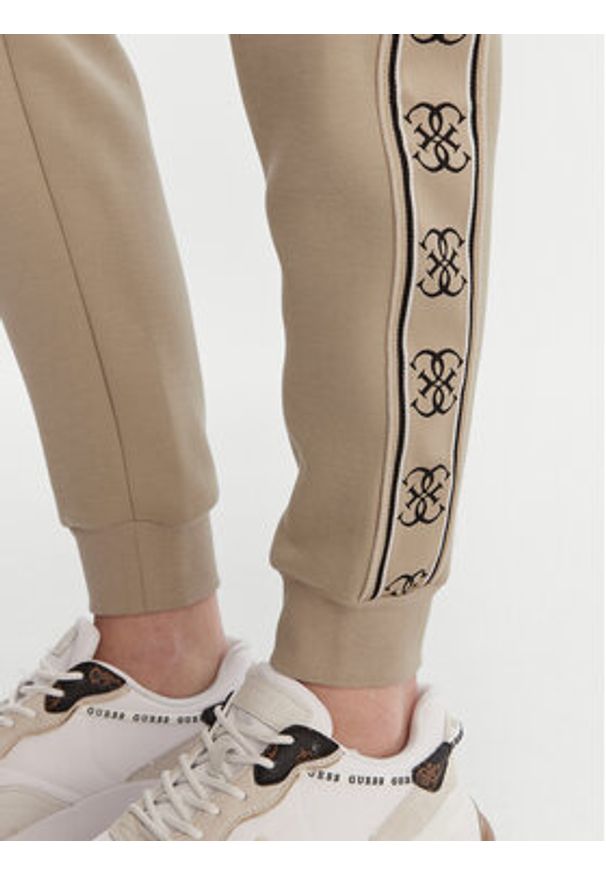 Guess Spodnie dresowe V2YB15 KB3P2 Beżowy Regular Fit. Kolor: beżowy. Materiał: syntetyk