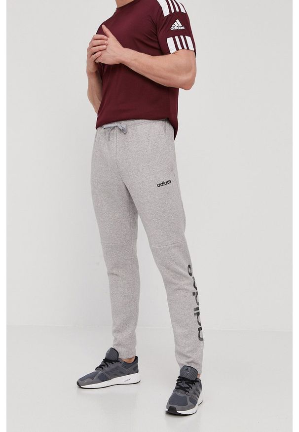 Adidas - Spodnie. Okazja: na co dzień. Kolor: szary. Materiał: dzianina, poliester. Wzór: nadruk. Styl: casual