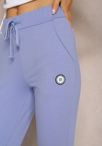 Renee - Niebieskie Spodnie Dresowe Ozdobione Małą Naszywką Nulorea. Kolor: niebieski. Materiał: dresówka. Długość: długie. Wzór: aplikacja