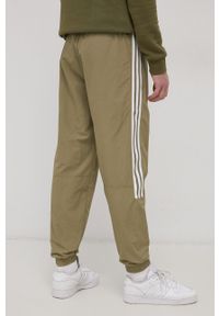 adidas Originals Spodnie męskie kolor zielony gładkie. Kolor: zielony. Materiał: materiał, tkanina. Wzór: gładki