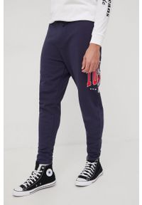 Tommy Jeans spodnie dresowe bawełniane męskie kolor granatowy z nadrukiem. Kolor: niebieski. Materiał: bawełna, dresówka. Wzór: nadruk