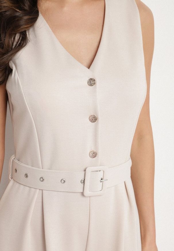 Born2be - Jasnobeżowy Taliowany Kombinezon z Wiskozą Ozdobiony Paskiem Ralinelle. Okazja: na imprezę. Kolor: beżowy. Materiał: wiskoza. Wzór: aplikacja. Styl: elegancki, klasyczny