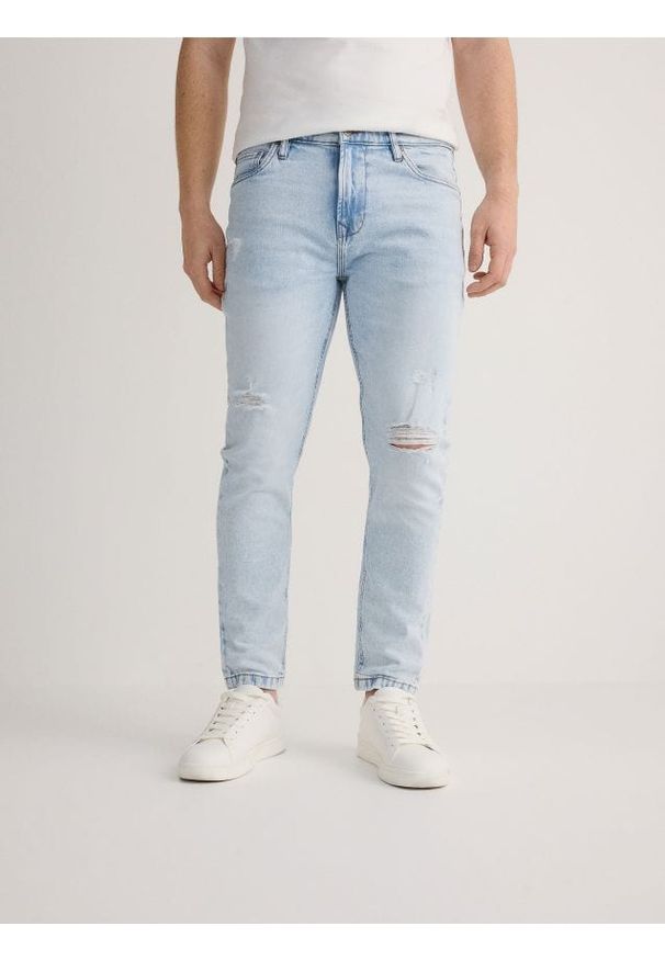 Reserved - Jeansy carrot slim z przetarciami - niebieski. Kolor: niebieski