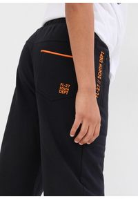 bonprix - Spodnie sportowe z miękkiej mieszanki z bawełną. Kolor: czarny. Materiał: bawełna. Wzór: nadruk. Styl: sportowy #3