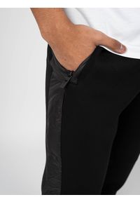 John Richmond - Richmond Sport Spodnie | UMA22012PA | Mężczyzna | Czarny. Okazja: na co dzień. Kolor: czarny. Materiał: nylon, elastan, wiskoza. Wzór: aplikacja. Styl: sportowy