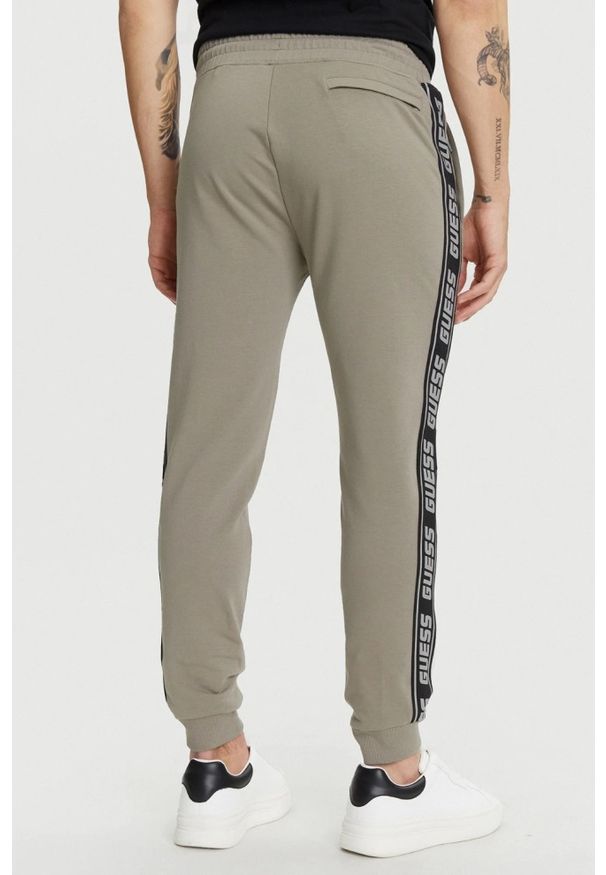 Guess - GUESS Zielone męskie spodnie dresowe z lampasami New Arlo, Rozmiar S. Kolor: zielony. Materiał: dresówka