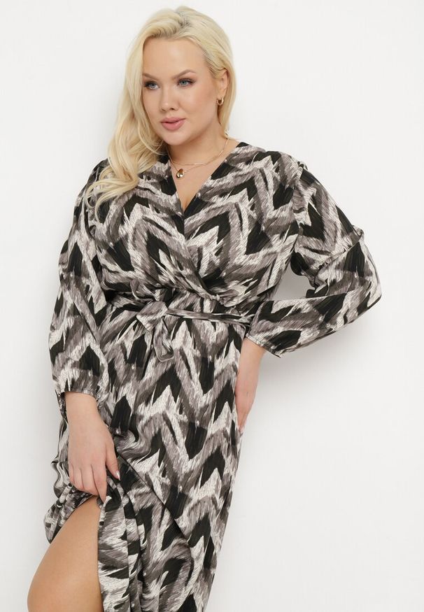 Born2be - Czarna Rozkloszowana Sukienka o Kopertowym Kroju z Paskiem i Gumką w Pasie Bristella. Okazja: na spotkanie biznesowe, do pracy. Kolekcja: plus size. Kolor: czarny. Długość rękawa: długi rękaw. Wzór: aplikacja. Typ sukienki: kopertowe. Styl: biznesowy