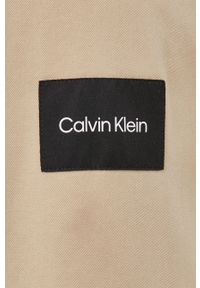 Calvin Klein koszula męska kolor beżowy regular z kołnierzykiem klasycznym. Typ kołnierza: kołnierzyk klasyczny. Kolor: beżowy. Materiał: materiał. Długość rękawa: długi rękaw. Długość: długie. Styl: klasyczny