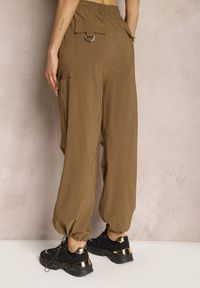Renee - Brązowe Szerokie Spodnie High Waist w Stylu Bojówek Wykończone Gumką w Talii Ellcara. Okazja: na co dzień. Stan: podwyższony. Kolor: brązowy. Materiał: satyna. Wzór: moro. Styl: elegancki, wizytowy, sportowy, militarny, casual #5