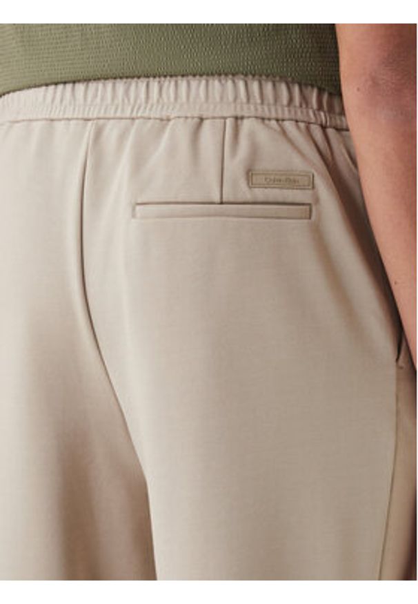 Calvin Klein Spodnie materiałowe LV04LF607G Beżowy Tapered Fit. Kolor: beżowy. Materiał: wiskoza