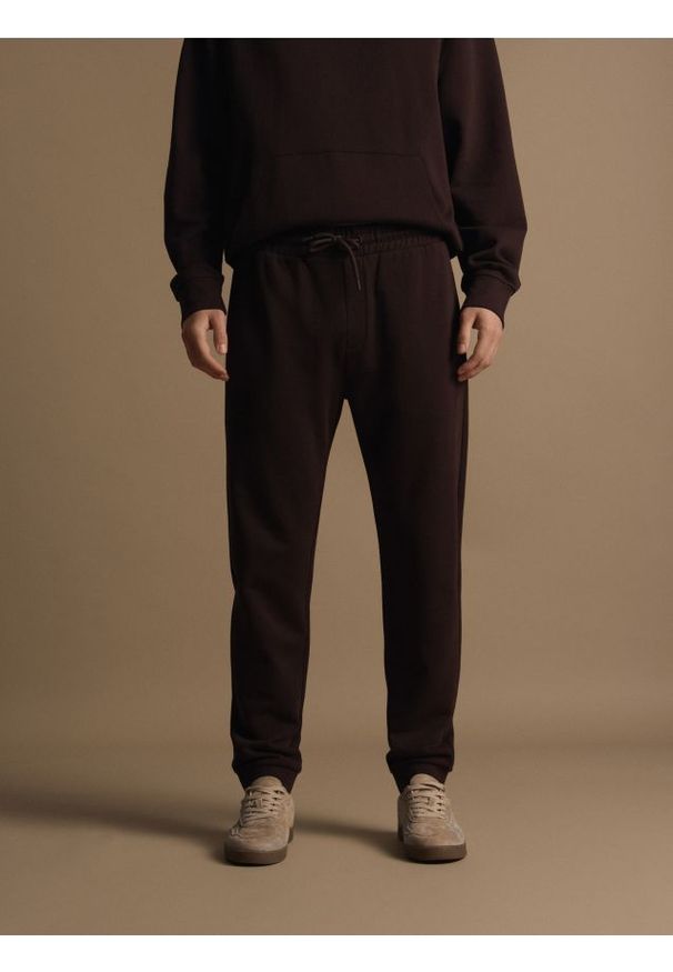 Reserved - Bawełniane spodnie dresowe - ciemnobrązowy. Kolor: brązowy. Materiał: bawełna, dresówka