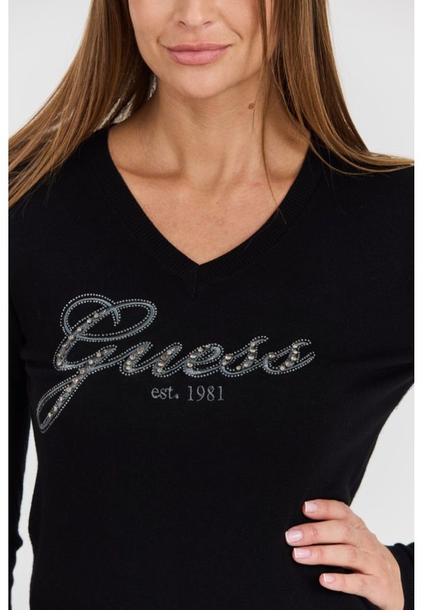 Guess - GUESS Czarny damski sweter Saige Logo Vn Ls Swtr. Typ kołnierza: dekolt w serek. Kolor: czarny. Materiał: materiał. Długość rękawa: długi rękaw. Długość: długie. Styl: elegancki