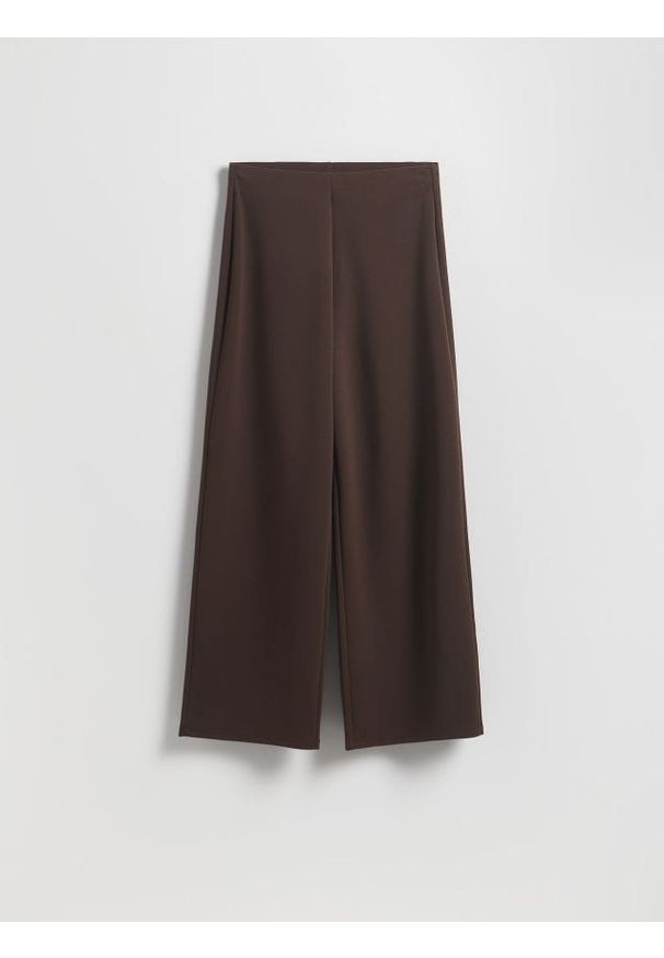 Reserved - Spodnie z szerokimi nogawkami - ciemnobrązowy. Kolor: brązowy. Materiał: tkanina. Wzór: gładki