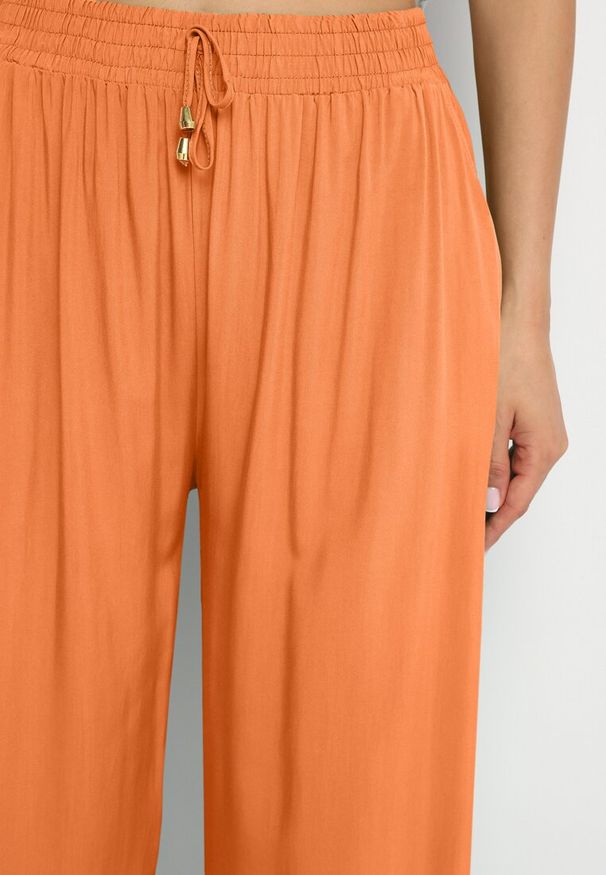 Born2be - Pomarańczowe Gładkie Spodnie z Gumką w Pasie i Szerokimi Nogawkami Alathera. Kolor: pomarańczowy. Wzór: gładki. Sezon: lato