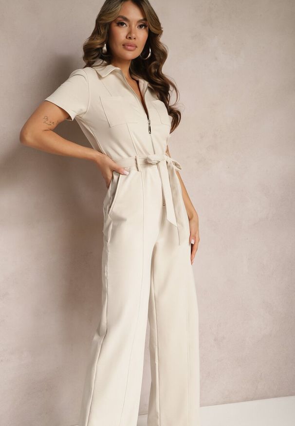 Renee - Jasnobeżowy Kombinezon z Elastycznej Bawełny z Suwakiem i Wiązanym Paskiem Ecatra. Kolekcja: dla wysokich. Kolor: beżowy. Materiał: bawełna. Sezon: lato