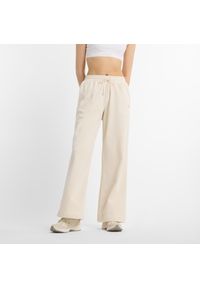 Spodnie damskie New Balance WP51503LIN – beżowe. Kolor: beżowy. Materiał: bawełna, poliester. Wzór: haft, aplikacja #1