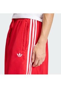 Adidas - adidas Spodnie dresowe Firebird Adilenium KD6299 Czerwony Regular Fit. Kolor: czerwony. Materiał: syntetyk #4