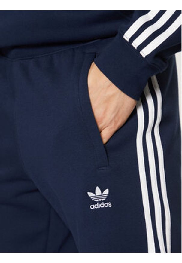 Adidas - adidas Spodnie dresowe adicolor 3-Stripes IM9319 Granatowy Slim Fit. Kolor: niebieski. Materiał: syntetyk, bawełna
