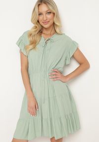 Born2be - Miętowa Sukienka z Gumką w Pasie Ozdobiona Falbanką i Wiązana Materiałowym Paskiem Tiamalou. Typ kołnierza: dekolt w łódkę. Kolor: miętowy. Materiał: materiał. Długość rękawa: krótki rękaw. Wzór: aplikacja #1