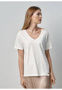 Ochnik - Kremowy T-shirt damski z rozcięciem. Kolor: biały. Materiał: bawełna
