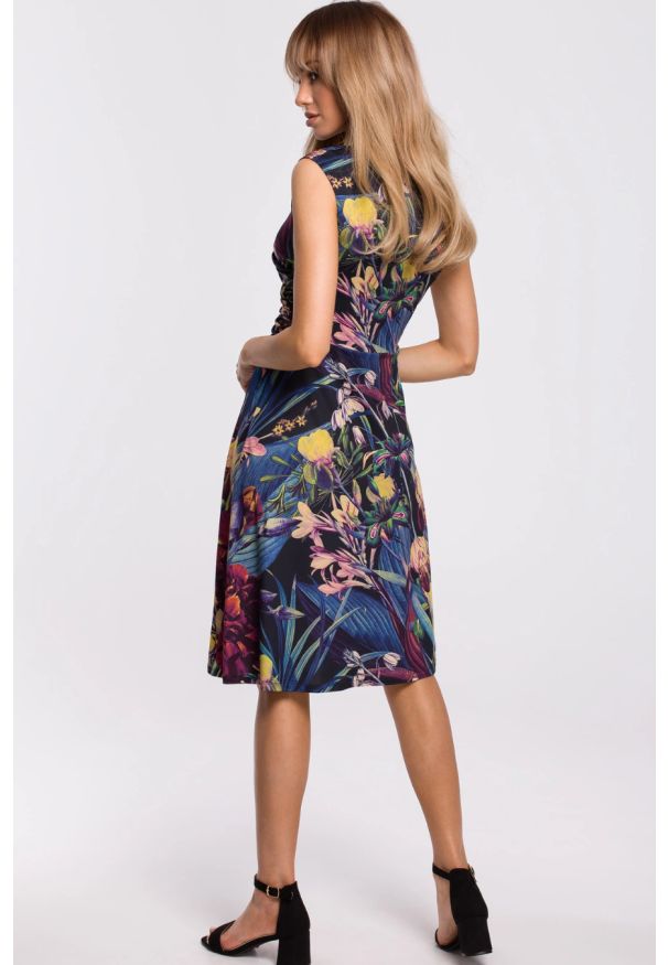 Sukienki.shop - Sukienka w kwiaty z kopertowym dekoltem granatowa. Okazja: na imprezę, na urodziny, na randkę. Kolor: niebieski. Materiał: dzianina, materiał, elastan. Wzór: kwiaty. Typ sukienki: kopertowe. Styl: klasyczny, elegancki. Długość: midi