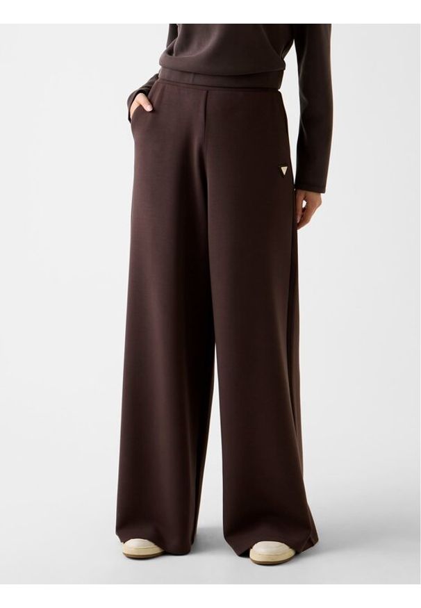 Guess Spodnie dresowe V4YB07 KCAY2 Brązowy Relaxed Fit. Kolor: brązowy. Materiał: dresówka