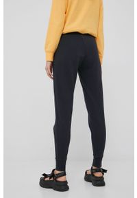 New Balance spodnie damskie kolor czarny z nadrukiem. Kolor: czarny. Wzór: nadruk