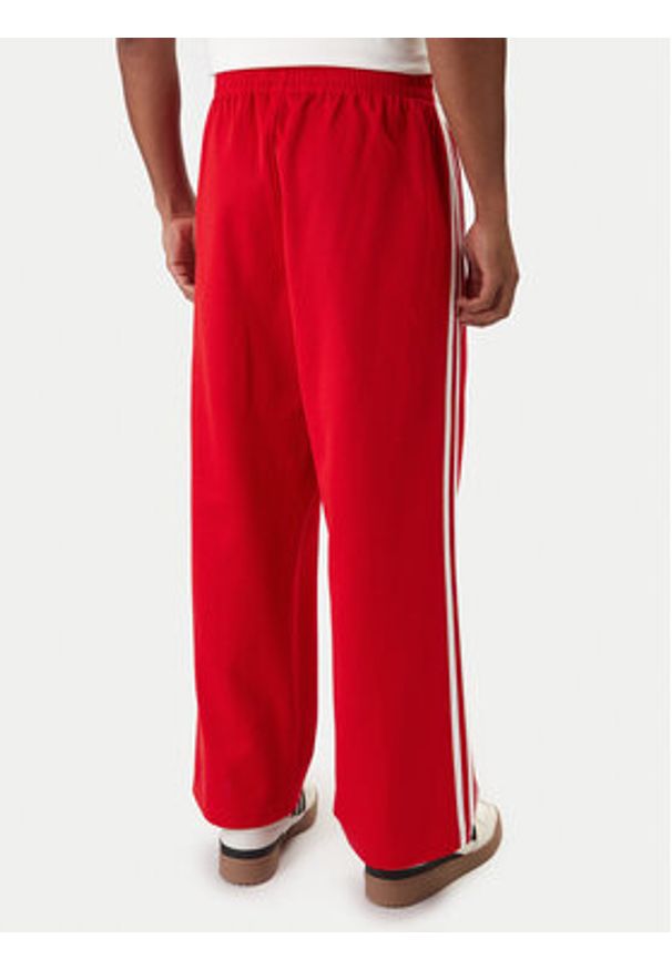 Adidas - adidas Spodnie dresowe adicolor KE3498 Czerwony Loose Fit. Kolor: czerwony. Materiał: bawełna