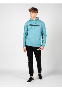 Champion Bluza "Hoodie" | HBGF89H586N9A | Mężczyzna | Błękitny. Okazja: na co dzień. Typ kołnierza: kaptur. Kolor: niebieski. Materiał: poliester, bawełna. Wzór: aplikacja. Styl: casual