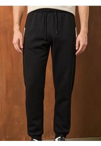 Sinsay - Spodnie dresowe - czarny. Kolor: czarny. Materiał: dresówka #1