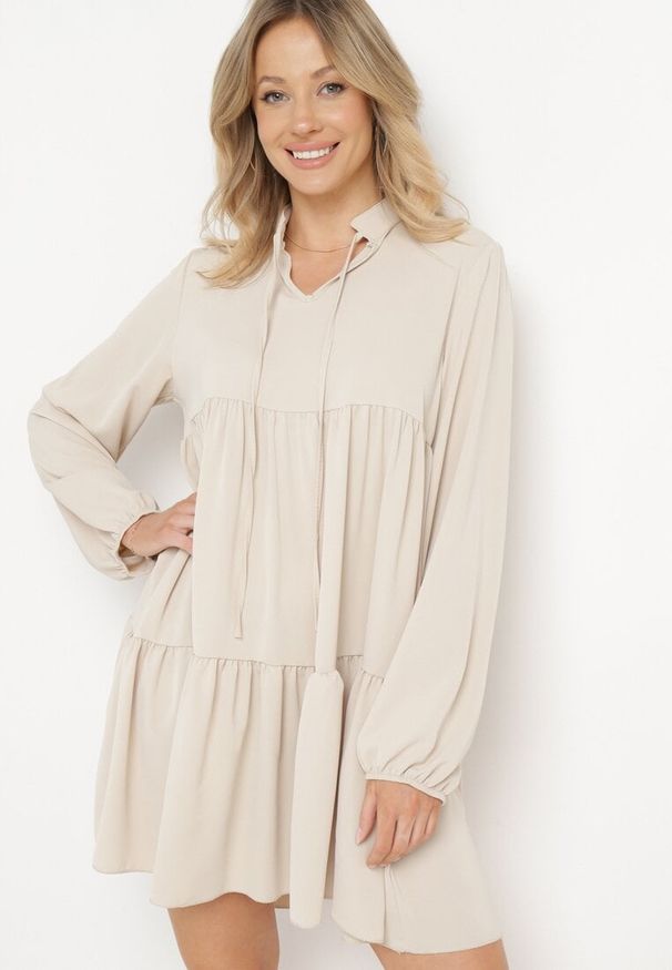 Born2be - Beżowa Rozkloszowana Sukienka z Falbanką Uxaria. Typ kołnierza: kołnierz z falbankami. Kolor: beżowy. Długość rękawa: długi rękaw. Wzór: aplikacja. Styl: elegancki