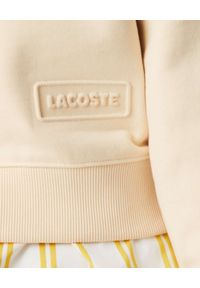 Lacoste - LACOSTE - Beżowa bluza z metalowym logo. Kolor: beżowy. Materiał: bawełna, prążkowany, polar. Długość rękawa: raglanowy rękaw. Długość: długie #6