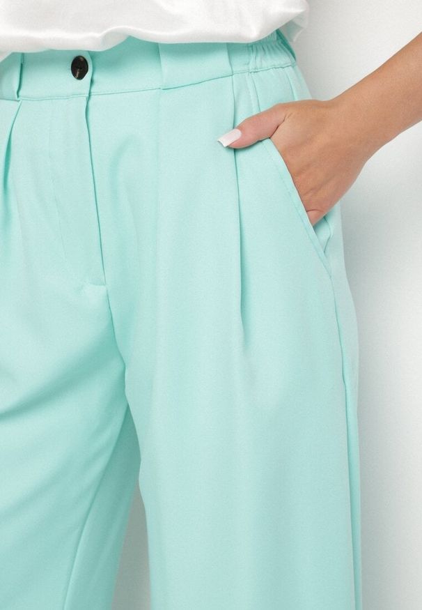 Born2be - Jasnozielone Spodnie Garniturowe o Szerokim Kroju z Zakładkami i Wysokim Stanem Ulianeria. Okazja: na co dzień, na spotkanie biznesowe, do pracy. Stan: podwyższony. Kolor: zielony. Styl: casual, biznesowy, klasyczny