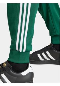 Adidas - adidas Spodnie dresowe adicolor Classics SST IR9886 Zielony Slim Fit. Kolor: zielony. Materiał: bawełna, syntetyk