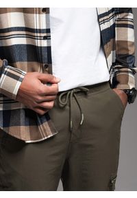 Ombre Clothing - Męskie spodnie joggery z kieszeniami cargo i printem – ciemnooliwkowe V5. Okazja: na co dzień. Kolor: oliwkowy. Materiał: guma, tkanina, poliester, materiał, bawełna, elastan. Wzór: nadruk. Styl: casual #6