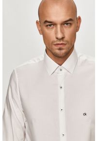 Calvin Klein - Koszula bawełniana. Typ kołnierza: kołnierzyk klasyczny. Kolor: biały. Materiał: bawełna. Długość rękawa: długi rękaw. Długość: długie. Wzór: gładki. Styl: elegancki, klasyczny #1