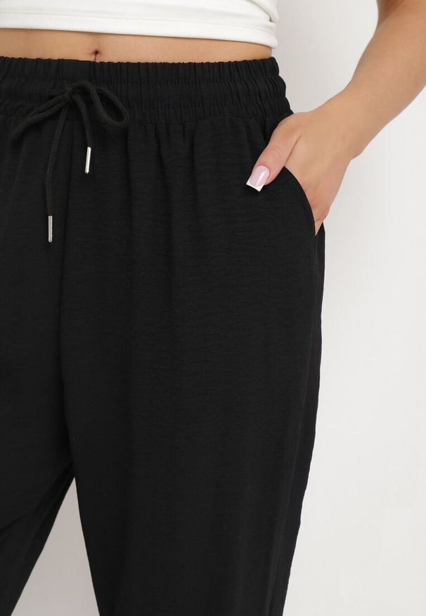Born2be - Czarne Spodnie Luźne z Kieszeniami i Gumką w Talii oraz Sznurkiem Enivia. Okazja: na co dzień. Kolor: czarny. Styl: elegancki, casual
