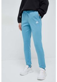 Adidas - adidas spodnie dresowe bawełniane kolor niebieski z nadrukiem. Kolor: niebieski. Materiał: bawełna, dresówka. Wzór: nadruk #1