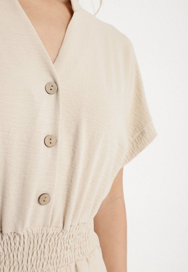 Born2be - Beżowy Kombinezon z Wiskozy z Gumką w Talii i Dekoltem w Serek z Guzikami Nisella. Okazja: na co dzień. Kolor: beżowy. Materiał: wiskoza. Długość rękawa: krótki rękaw. Długość: krótkie. Styl: elegancki, casual