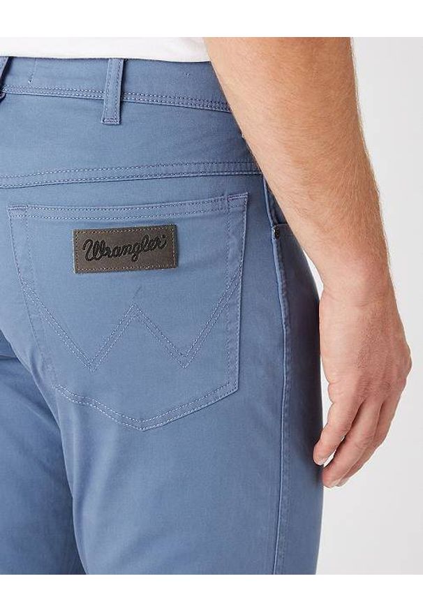 Wrangler - WRANGLER TEXAS SLIM MĘSKIE SPODNIE MATERIAŁOWE BLUE MIRAGE W12SEAXOD 112145793. Materiał: materiał