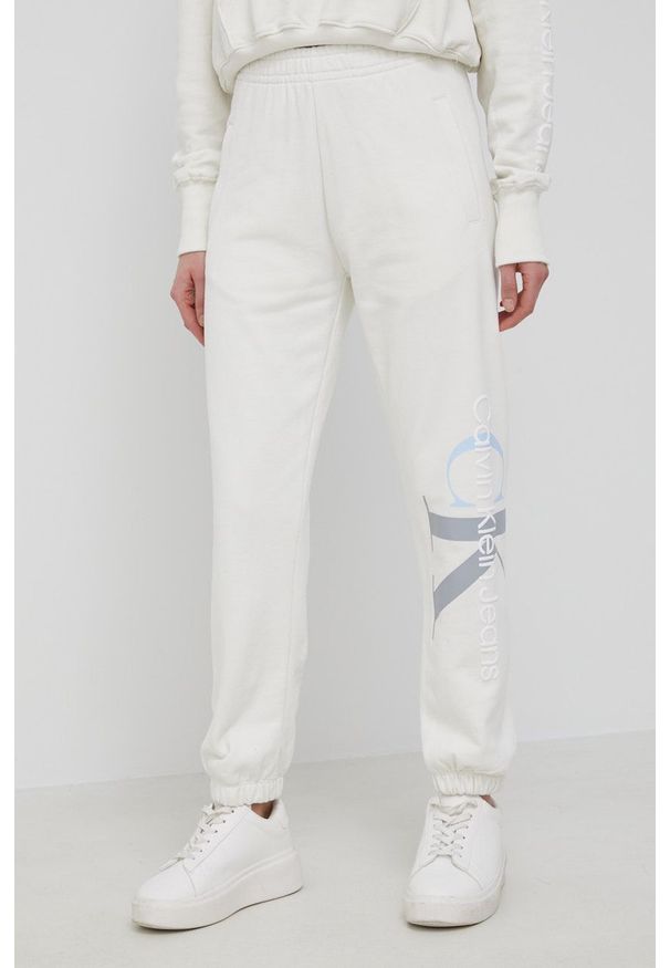 Calvin Klein Jeans Spodnie bawełniane J20J217786.PPYY damskie kolor beżowy z nadrukiem. Stan: podwyższony. Kolor: beżowy. Materiał: bawełna. Wzór: nadruk