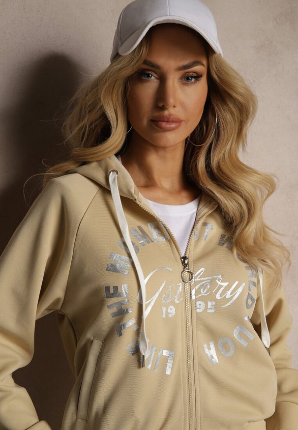Renee - Beżowy Komplet Dresowy Spodnie Ozdobione Napisami Bluza na Suwak z Kapturem Semiraella. Kolor: beżowy. Materiał: dresówka. Wzór: napisy, aplikacja. Sport: turystyka piesza, fitness