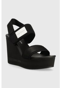 Calvin Klein Jeans sandały WEDGE SANDAL BADGE damskie kolor czarny na koturnie YW0YW01028. Zapięcie: rzepy. Kolor: czarny. Materiał: materiał, guma. Wzór: gładki. Obcas: na koturnie #4